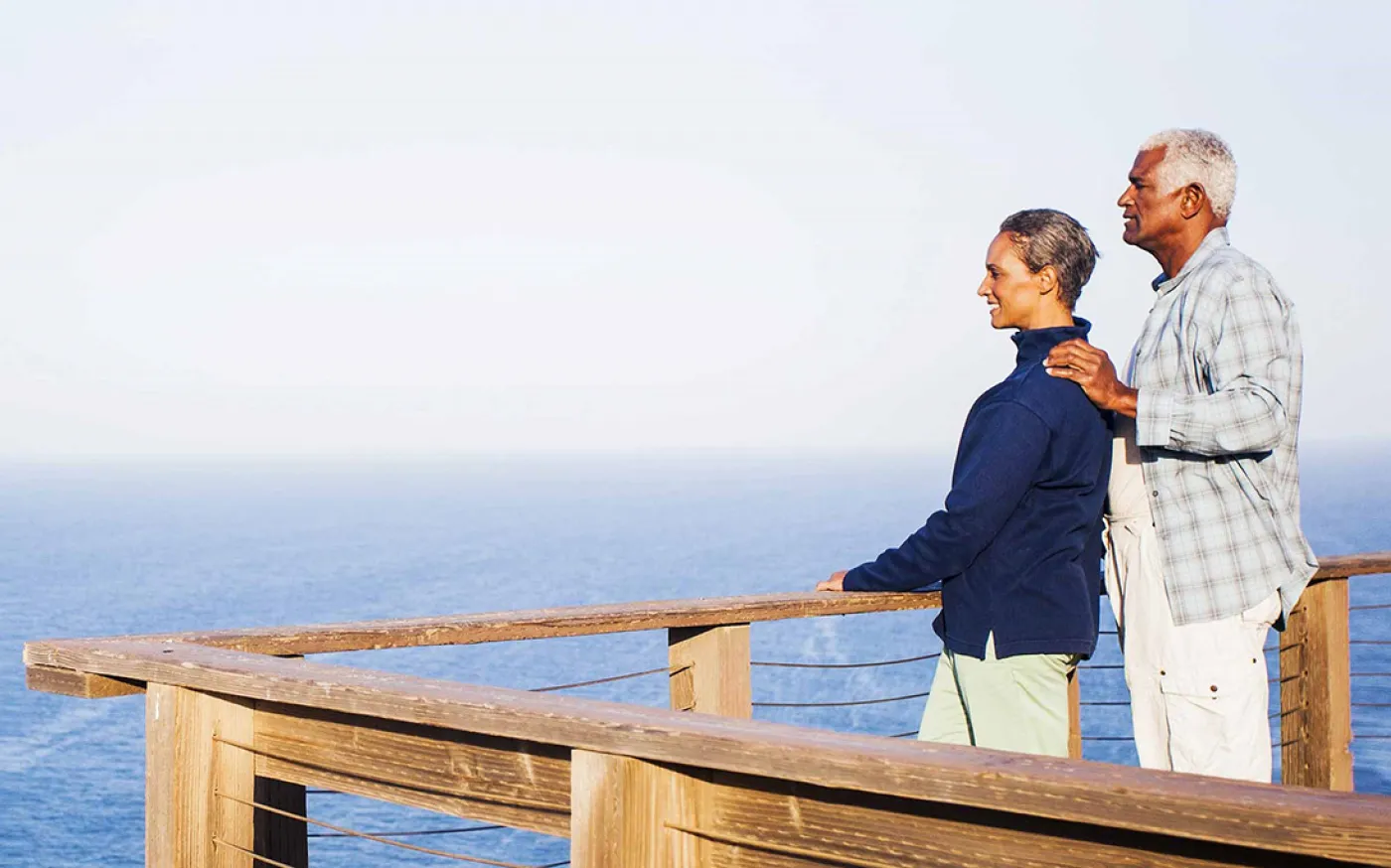 A couple on a dock looks at the ocean