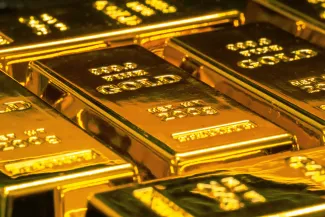 stacked gold bullion bars by Jingming Pan courtesy of Unsplash.