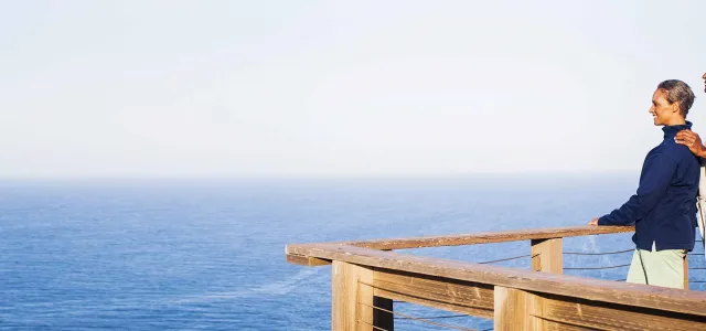 A couple on a dock looks at the ocean